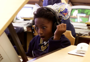 Eight year old Jenni-Lee Mason stares in awe as she uses a computer for the first time at a township school in Cape Town, South Africa. (Reuters)