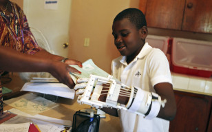 Handicapped Haitian boy Stevenson Joseph learns to use a 3D-printed prosthetic hand at the orphanage where he lives in Santo, near Port-au-Prince, April 28, 2014. (Reuters)