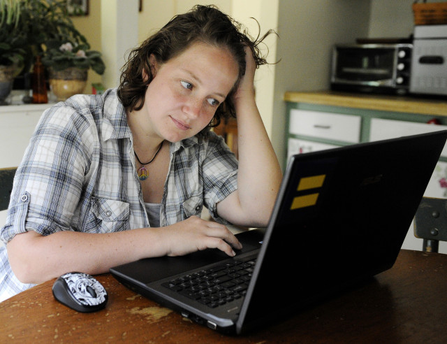 FILE - A young woman reads instant messages on her laptop screen at her home in Kings Park, N.Y. (AP)