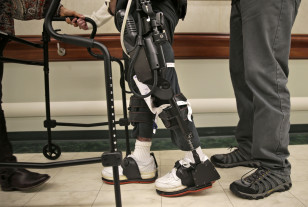 James Cody (C) walks with the aid of a bionic exoskeleton and physical therapists at the Burke Rehabilitation Center in White Plains, N.Y., Nov. 10, 2014. (AP)