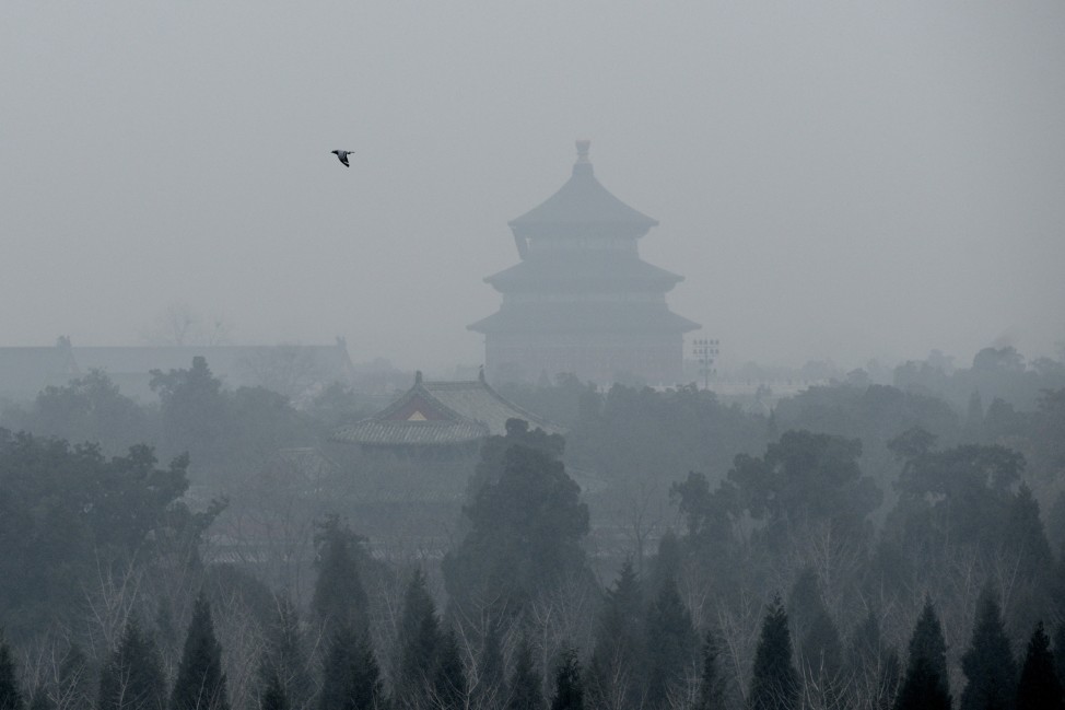 A bird flies over the grounds of the Temple of Heaven amid heavy air pollution in Beijing on Dec. 8, 2015. Half of Beijing's private cars were ordered off the streets on Dec. 8 and many construction sites and schools were closed under the Chinese capital's first-ever red alert for pollution. (AFP)  