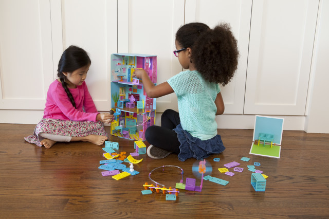 Isabella and Kira work together to complete their dollhouse, using Roominate bricks. (Roominate)