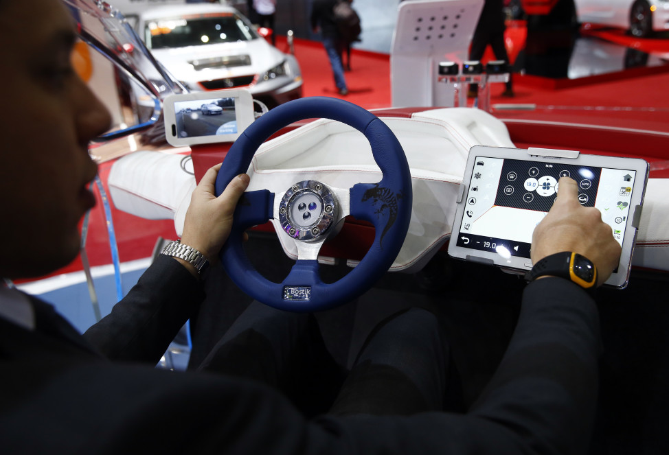 FILE - An employee sits inside a virtual reality connected car cockpit built by Segula Technologies during the first press day ahead of the 85th International Motor Show in Geneva, Switzerland, March 3, 2015.  (Reuters)