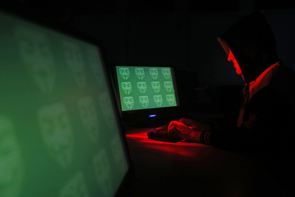 FILE - A man poses in front of on a computer display showing the word 'cyber' in binary code, in this picture illustration taken in Zenica, Bosnia and Herzegovina. (Reuters)