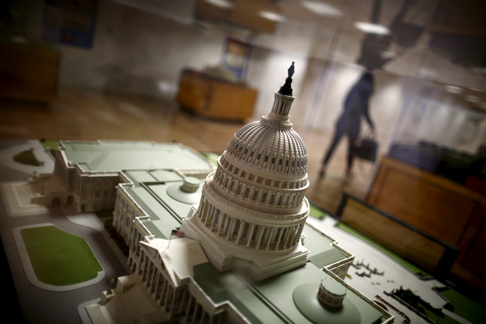 A woman walks by a miniature of the Capitol building at the Hart Senate Office Building at Capitol Hill in Washington, Jan. 20, 2016.