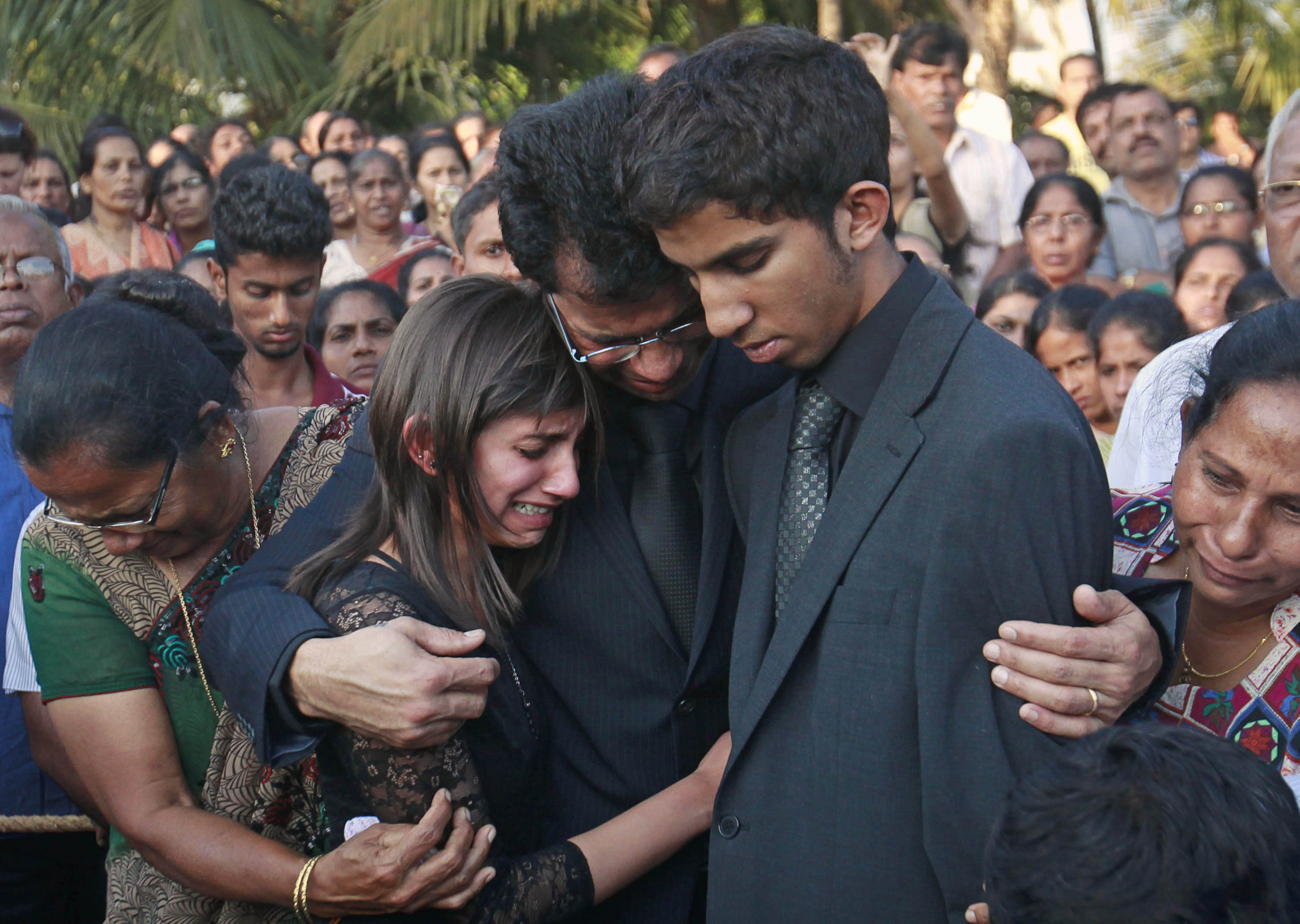 FILE - Jacintha Saldanha's widower Ben Barboza (C) and her children Lisha (2nd L) and Junal (2nd R) mourn during her funeral at a cemetery in Shirva, north of Mangalore Dec. 17, 2012. 