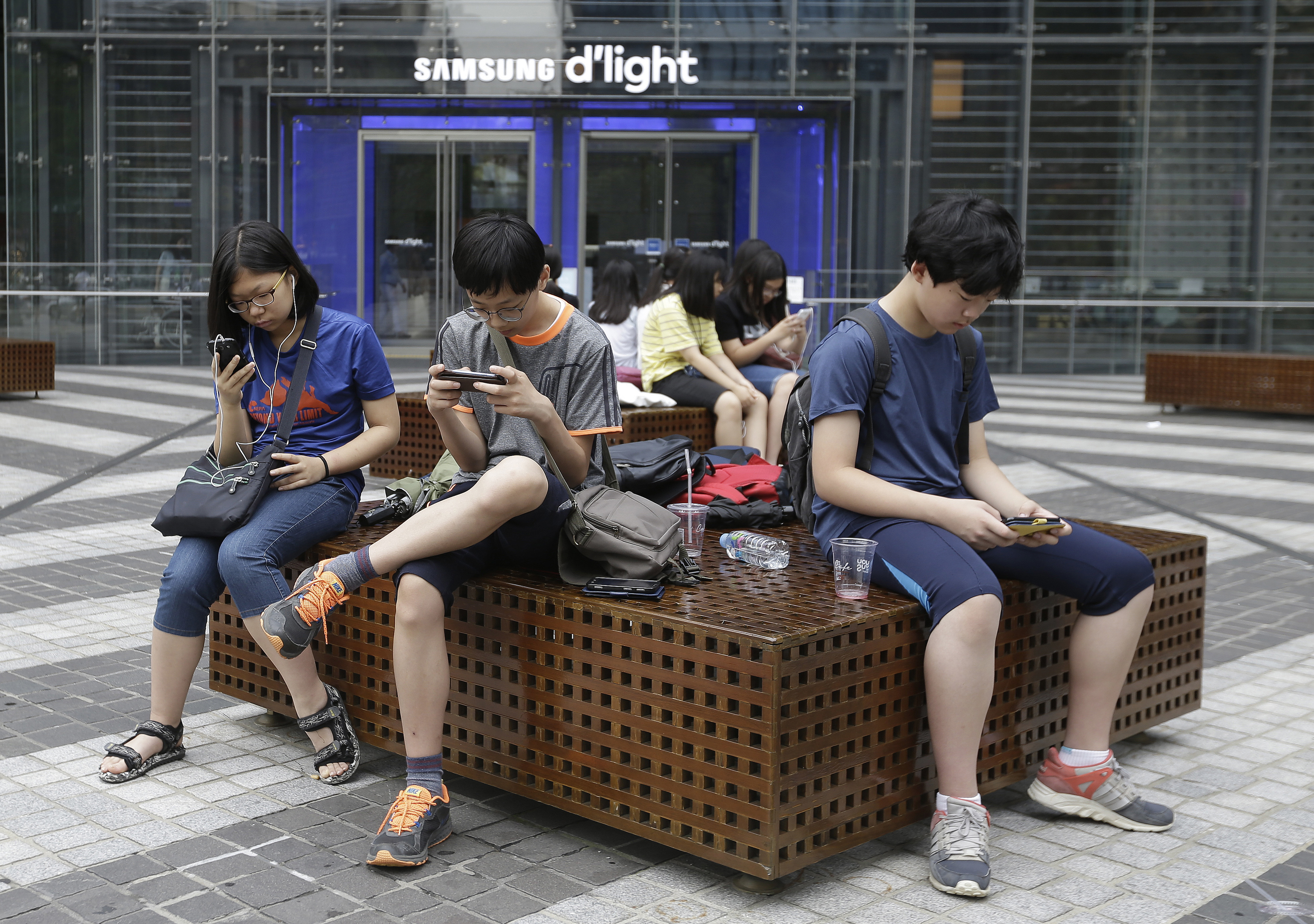 Middle school students use their smartphones in Seoul, South Korea, July 7, 2016. (AP)