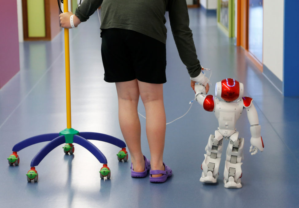 Belgian Ian Frejean, 11, walks with "Zora" the robot, a humanoid robot designed to entertain patients and to support care providers, at AZ Damiaan hospital in Ostend, Belgium June 16, 2016. (Reuters)