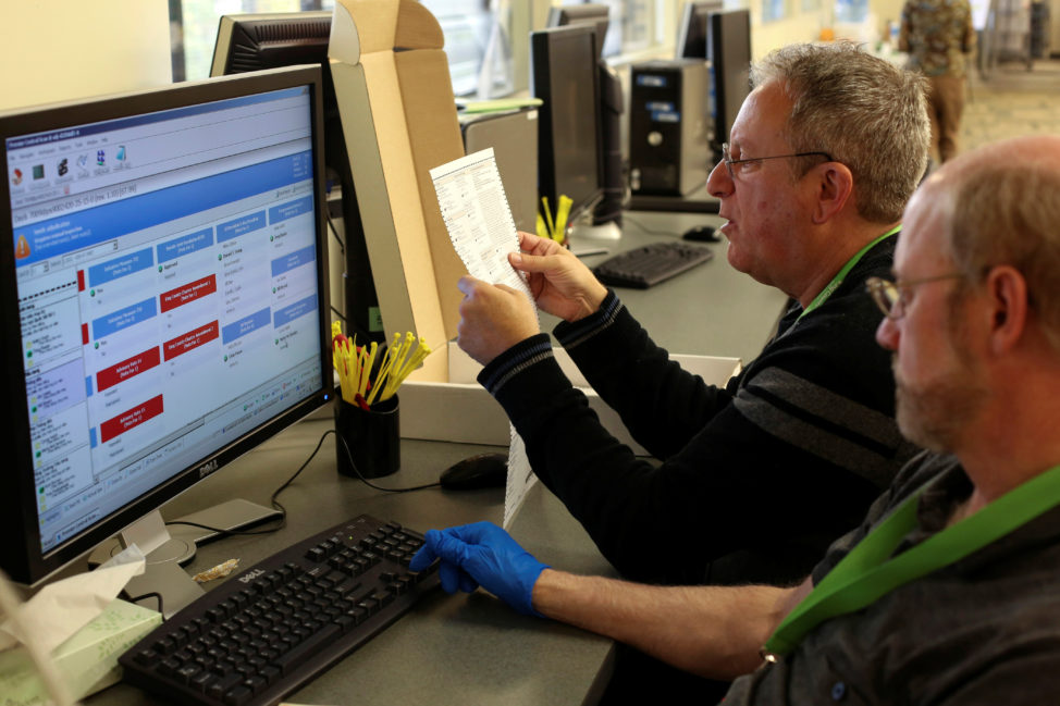 Temporary elections employees record votes from a ballot that a machine was not able to process at the King County Department of Elections in Renton, Washington Nov. 7, 2016. (Reuters)