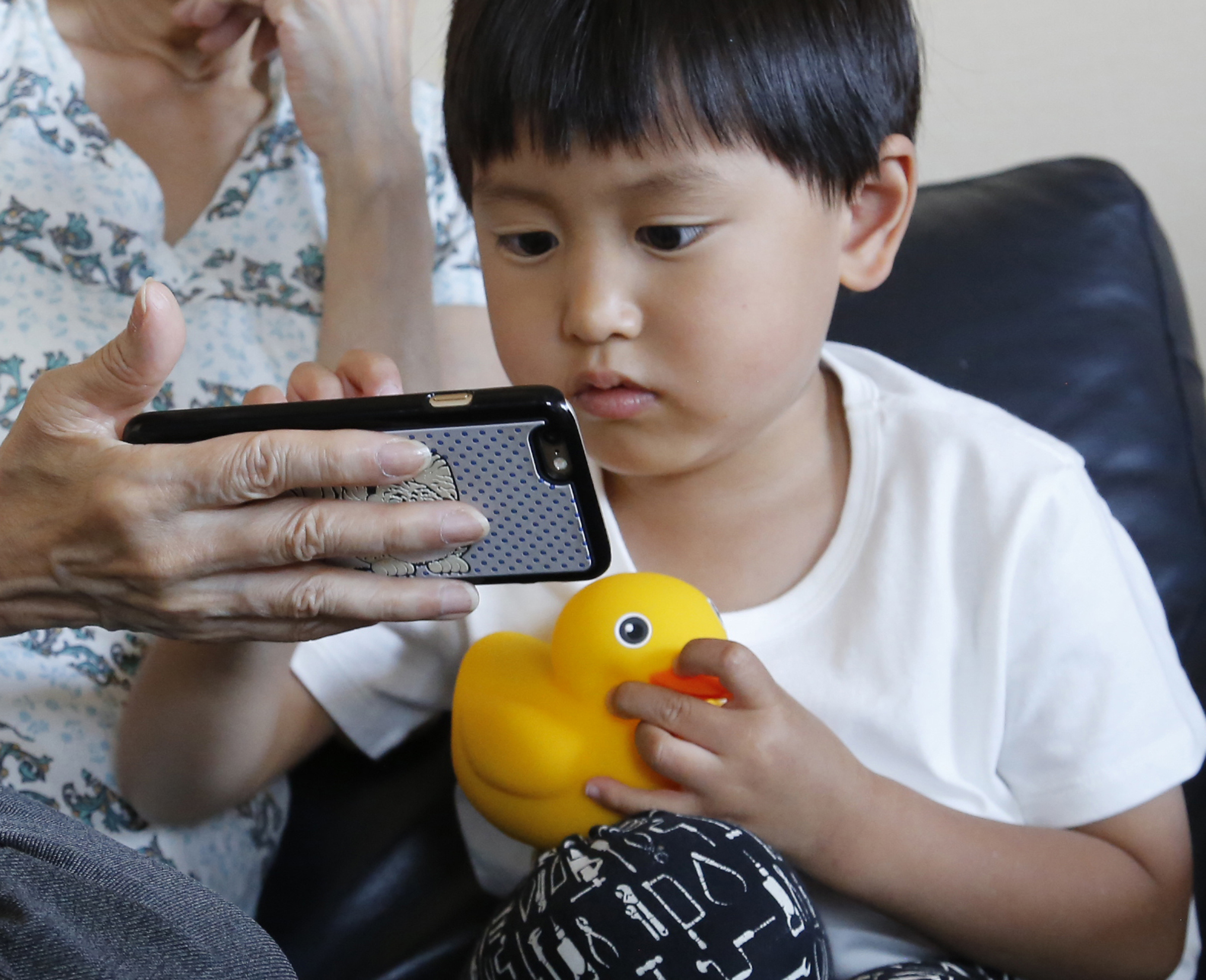 FILE - Yui Matusmoto, 4, plays with Edwin the Duck, a digital duck toy, in the living room of his home in Tokyo, In this Monday, May 23, 2016,.