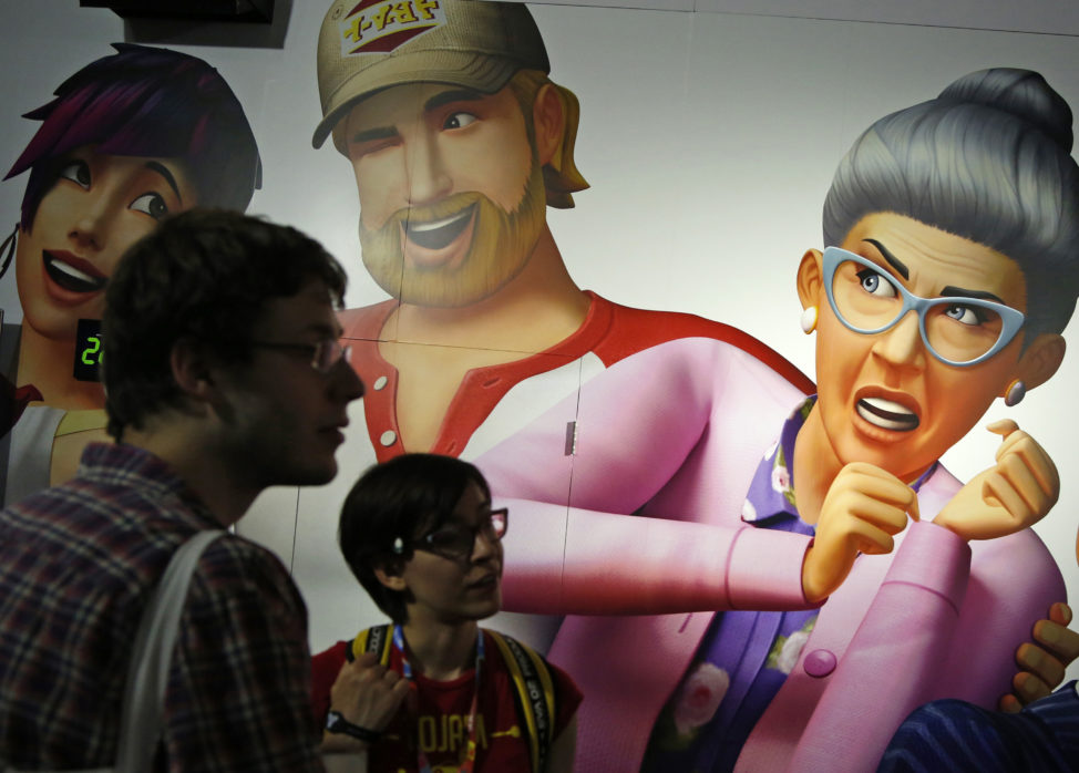 FILE - People stand near 'Sims 4' game characters on a wall during the 2014 Electronic Entertainment Expo, known as E3, in Los Angeles, California June 11, 2014. (Reuters)