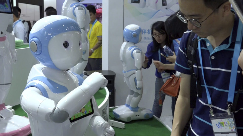 In this image taken from video, visitors look at iPal robots during the Shanghai CES electronic show in Shanghai, China, June 8, 2017. (AP)