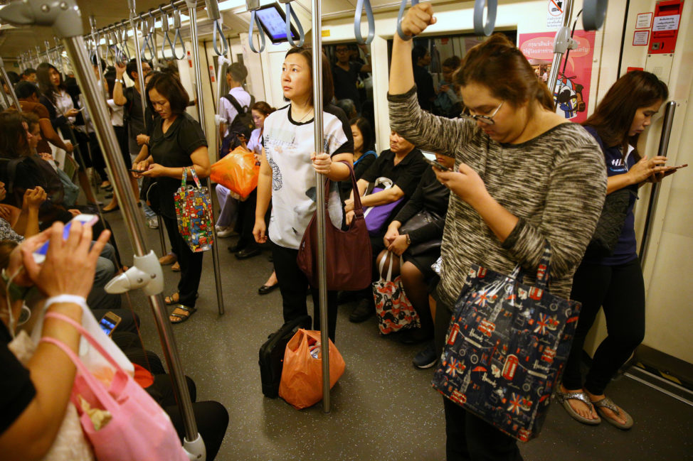 Passengers use their mobile phones as they ride a train in Bangkok, Thailand, June 12, 2017. (Reuters) 