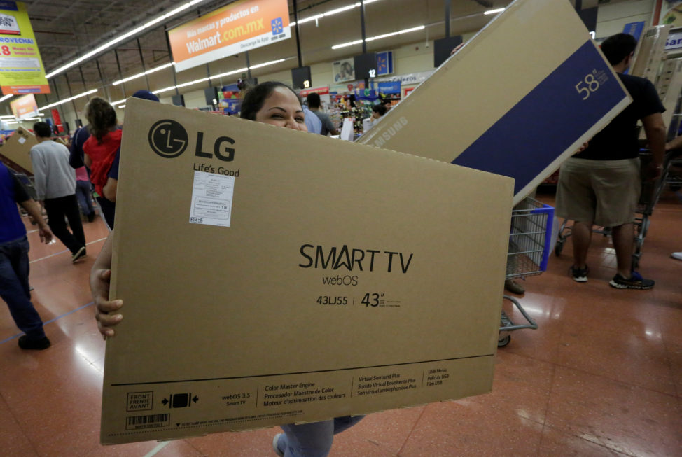 FILE - A shopper carries a Smart TV during the holiday shopping season, at a Walmart store in Monterrey, Mexico, Nov. 17, 2017. (Reuters)