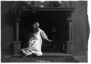 A little girl wonders whether this is where Santa lives.  I’ve picked just old-timey photos to illustrate this posting, in keeping with the times in which the elderly folks in my story enjoyed Christmas as kids.  (Library of Congress)