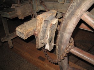 That’s a ordinary shoe, all right, between the pieces of wood in the braking device of an old Conestoga wagon.  (Ted Landphair)