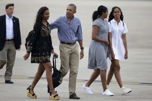President Barack Obama, center, and first lady Michelle Obama, second from right, walk with their daughters, Sasha, left, and Malia on the tarmac to board Air Force One at the Cape Cod Coast Guard Station, in Bourne, Mass., Sunday, Aug. 21, 2016. President Obama and the first family are returning to Washington D.C. following their vacation on the island of Martha's Vineyard, in Massachusetts. (AP Photo/Steven Senne)
