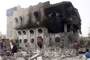 People salvage belongings from a government bank that was hit during an air strike in Yemen's northwestern city of Saada April 16, 2015. (Reuters)