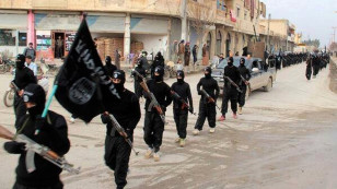 FILE - This undated file image posted on a militant website on Jan. 14, 2014 shows Islamic State fighters marching in Raqqa, Syria. 