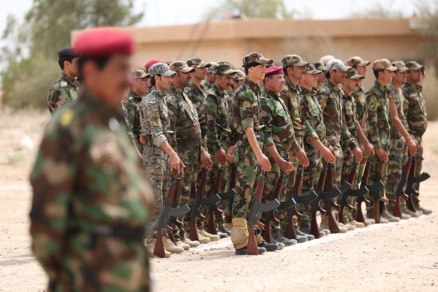 Sunni tribal volunteers stand in formation during their ceremony in the town of Amiriyat al-Fallujah, west of Baghdad, Iraq, May 8, 2015. (AP Photo/Hadi Mizban)