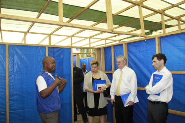 Senior Ebola Coordinator Denise Rollins, Associate Administrator Eric Postel, and National Security Council Senior Advisor Chris Kirchhoff listen as a staff member from the International Organization for Migration provides a tour of a mock-Ebola treatment unit in Freetown, Sierra Leone. (courtesy of  Kate Alexander/ USAID)