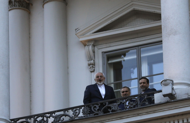 Iranian Foreign Minister Mohammad Javad Zarif, left, talks to journalist from a balcony of the Palais Coburg hotel where the Iran nuclear talks are being held in Vienna, Austria, Thursday, July 9, 2015. Long-standing differences persist over inspections of Iranian facilities and the Islamic republic's research and development of advanced nuclear technology. (Carlos Barria/Pool Photo via AP)