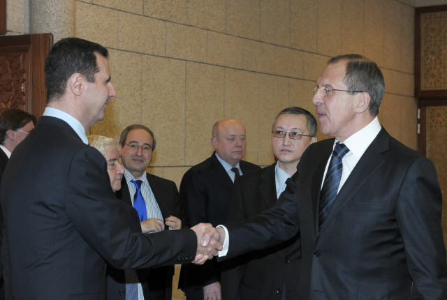 In this Feb. 7, 2012 file photo, Syrian President Bashar Assad, left, shakes hands with Russian Foreign Minister Sergey Lavrov.  Lavrov said on Sept. 10, 2015 that Russian aircraft flying into Syria are delivering weapons along with humanitarian supplies. (AP)