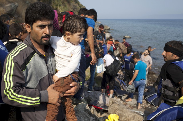 A Syrian refugee holds a boy moments after arriving on a dinghy on the Greek island of Lesbos Sept. 3, 2015. (Reuters)