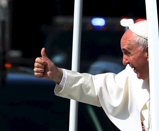 Pope Francis gives a thumbs up to the crowd as he  rides down Constitution Avenue in his Popemobile in Washington on day two of his first visit to the United States in Washington on Sept. 23, 2015. (Reuters)