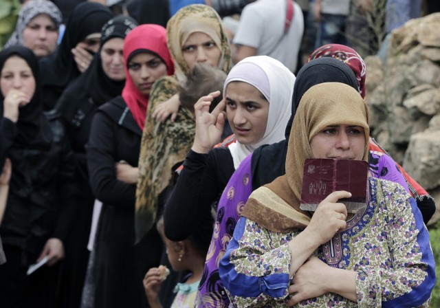 Syrian women wait in line to receive aid from an Islamic relief agency at a refugee camp in the town of Ketermaya in Lebanon on Sept. 7, 2015. (Reuters)