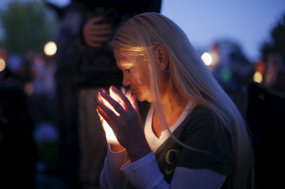 A woman takes part in a candlelight vigil for victims of the Umpqua Community College shooting, in Winston, Oregon on Oct. 3, 2015. (Reuters)