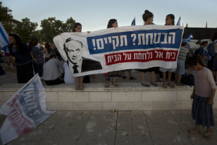 Israeli protesters hold a sign that reads: "You promised, keep the promise - Beit El fights for its home" during a demonstration against a court decision to demolish houses in the Jewish settlement of Beit El, in Jerusalem on July 8, 2015.  (AP)