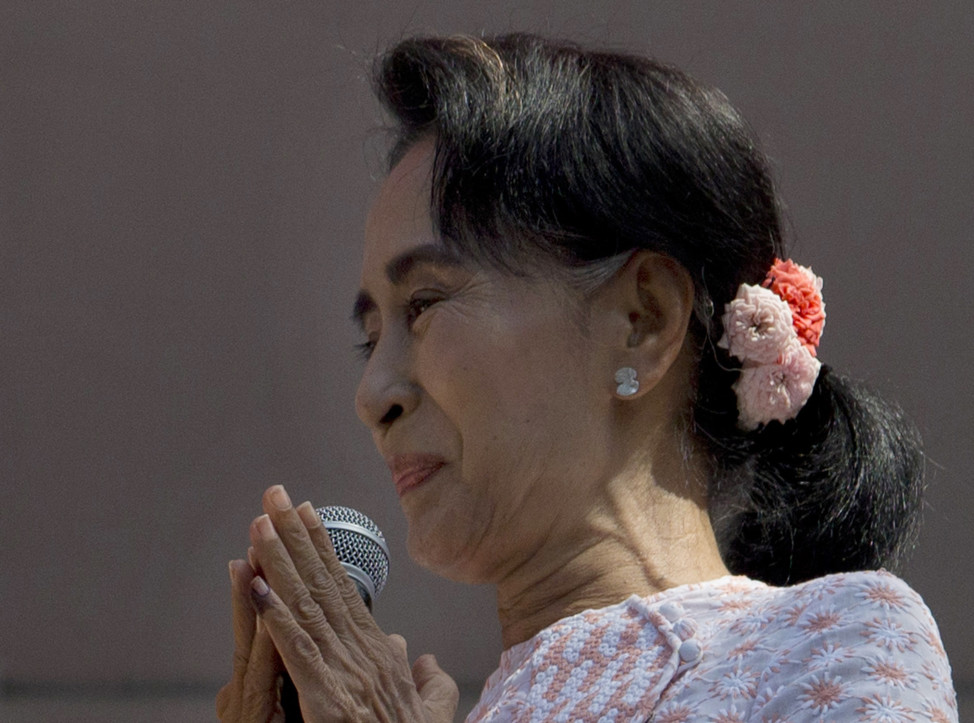 Burma's opposition leader Aung San Suu Kyi, with ink still imprinted on the little finger of her left hand after voting yesterday, prepares to deliver a speech from a balcony of the NLD headquarters in Yangon on Nov. 9, 2015. (AP)