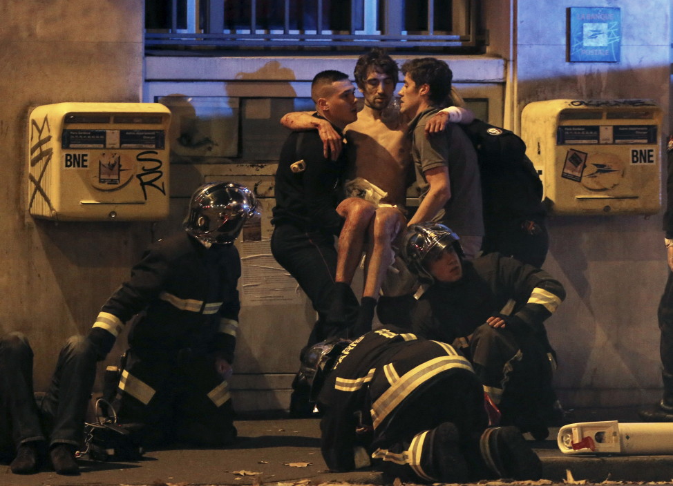 French fire brigade members aid an injured person near the Bataclan concert hall after the fatal shootings in Paris on Nov. 13, 2015. (AP)