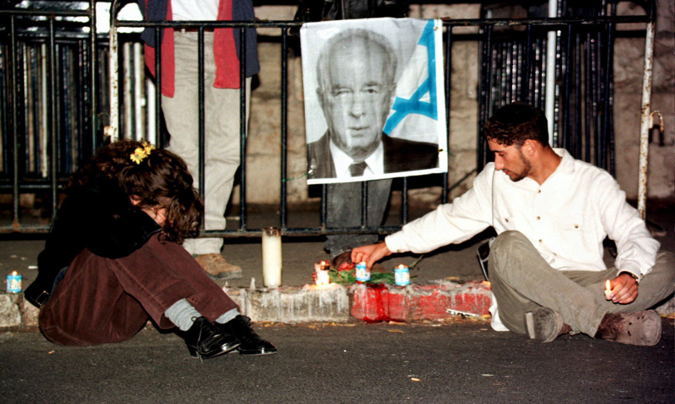 An Israeli woman cries as a man lights a candle beside a portrait of slain Israeli Prime Minister Yitzhak Rabin as mourners flock to Rabin's residence on Nov. 5, 1995, a day after he was assassinated. (Reuters). 