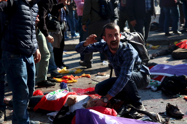 A man asks for help for an injured woman following deadly explosions during a peace march in Ankara, Turkey, Oct. 10, 2015. 