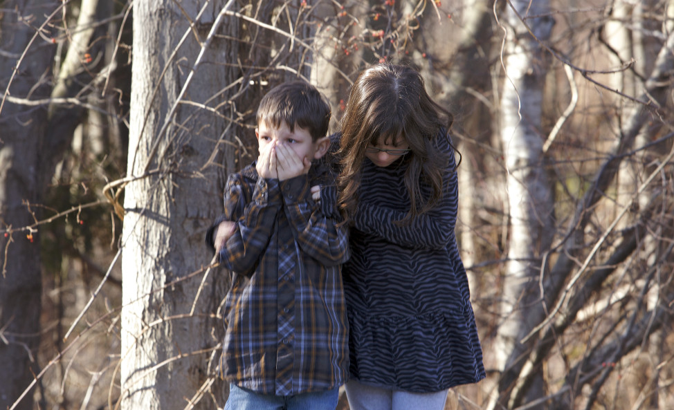 First-grader Henry Terifay and his sister, fourth-grader Kelly Terifay, wait outside Sandy Hook Elementary School after a shooting in Newtown, Connecticut, December 14, 2012. A shooter opened fire at the elementary school. REUTERS/