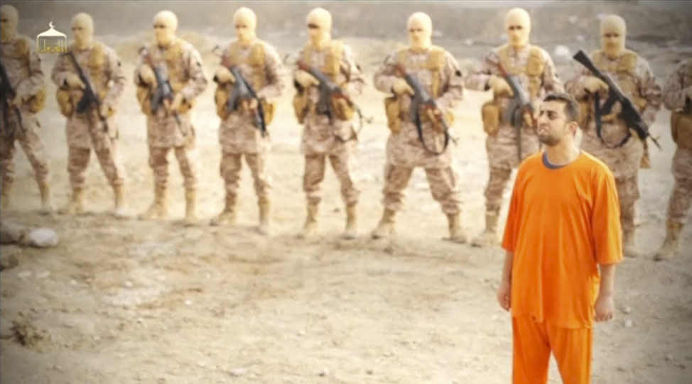 A man purported to be Islamic State captive Jordanian pilot Muath al-Kasaesbeh stands in front of armed men in this still image from an undated video posted online by Islamic State militants on Feb. 3, 2015 (Reuters)