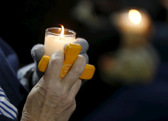 An attendee reflects on the tragedy of Wednesday's shooting attack, during a candlelight vigil in San Bernardino, California, December 3, 2015. REUTERS 