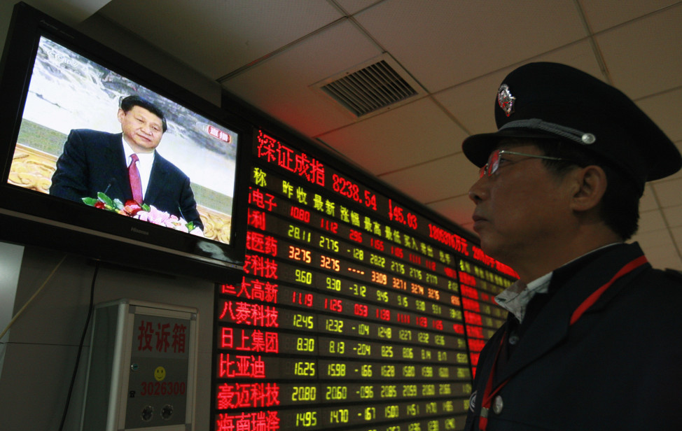 A security guard watches a screen showing Xi Jinping, the newly-elected General Secretary of the Central Committee of the Communist Party of China, holding a news conference in front of an electronic board showing stock information at a brokerage house in  Anhui province, China in this Nov. 15, 2012 file photo (Reuters)