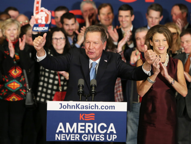 Republican presidential candidate John Kasich beams at the crowd with his wife Karen (R) at a presidential primary night rally in Concord, New Hampshire on Feb. 9, 2016.  