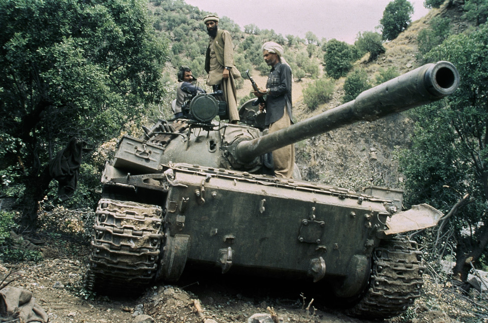 In this 1987 file photo,  mujahedeen guerrillas sit atop a captured Russian T-55 tank. (AP)