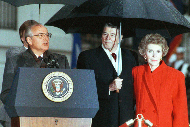 Former U.S. President Ronald Reagan (C) and his wife Nancy listen to former Soviet leader Mikhail Gorbachev (L) speak during Gorbachev's departure ceremony at the White House in Washington in this December 10, 1987 file photo. (Reuters)