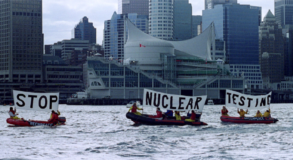 Greenpeace protesters man rubber boats in Burrard Inlet as they protest nuclear testing in the April 1993 file photo in Canada. (Reuters) . In the background with large white sail, is Canada Place, site of Sunday's joint news conference at the close of the summit between US and Russian Presidents - 