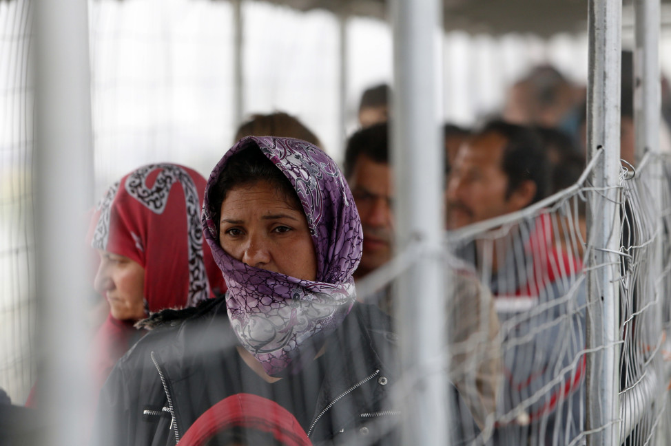 A migrant woman waits in a line to get food at the makeshift camp in the northern Greek border point of Idomeni on April 4, 2016. (AP)