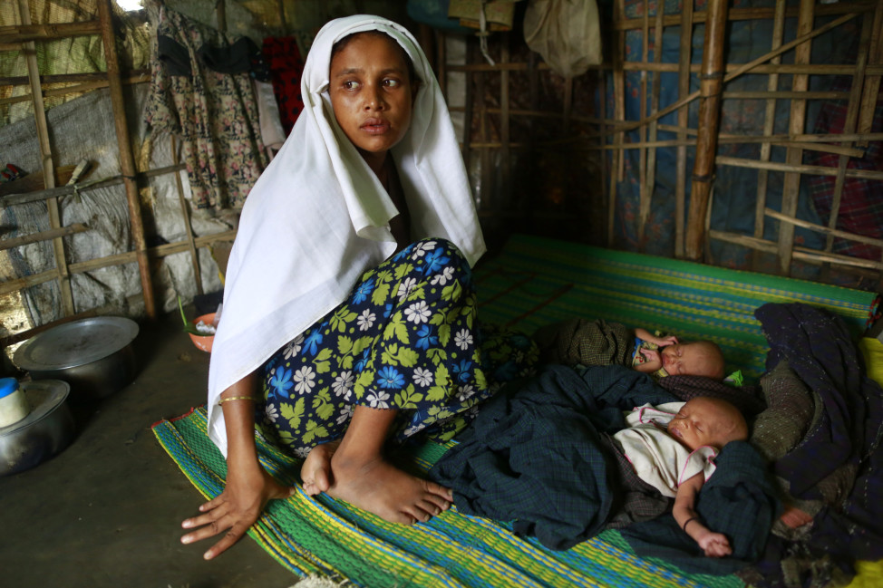 Sinnuyar Baekon, a ohingya Muslims, sits with her twin babies inside her hut at a refugee camp outside Sittwe, the capital city of the Rakhine state June 8, 2014.  (Reuters)