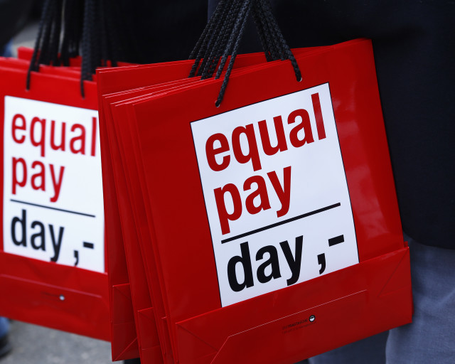 People carry bags reading 'equal pay day' during a protest a day before International Women's Day, in Bern, Germany March 7, 2015.  REUTERS