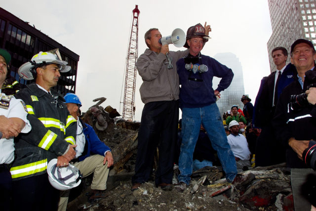 As rescue efforts continue in the rubble of the World Trade Center in New York, President Bush stands with firefighter Bob Beckwith on a burnt fire truck in front of the World Trade Center during a tour of the devastation, Friday, Sept. 14, 2001. (AP)