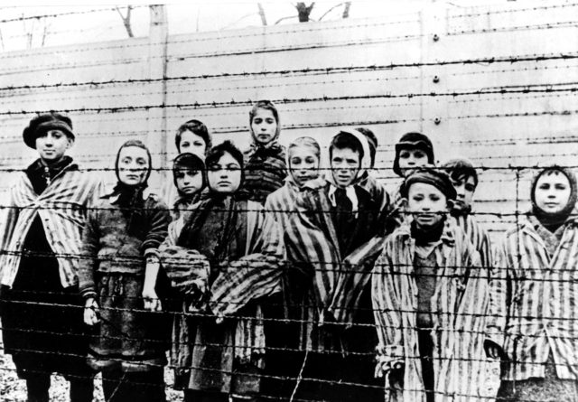 A picture taken just after the liberation by the Soviet army in January, 1945, shows a group of children wearing concentration camp uniforms at the time behind barbed wire fencing in the Oswiecim (Auschwitz) nazi concentration camp. (AP)