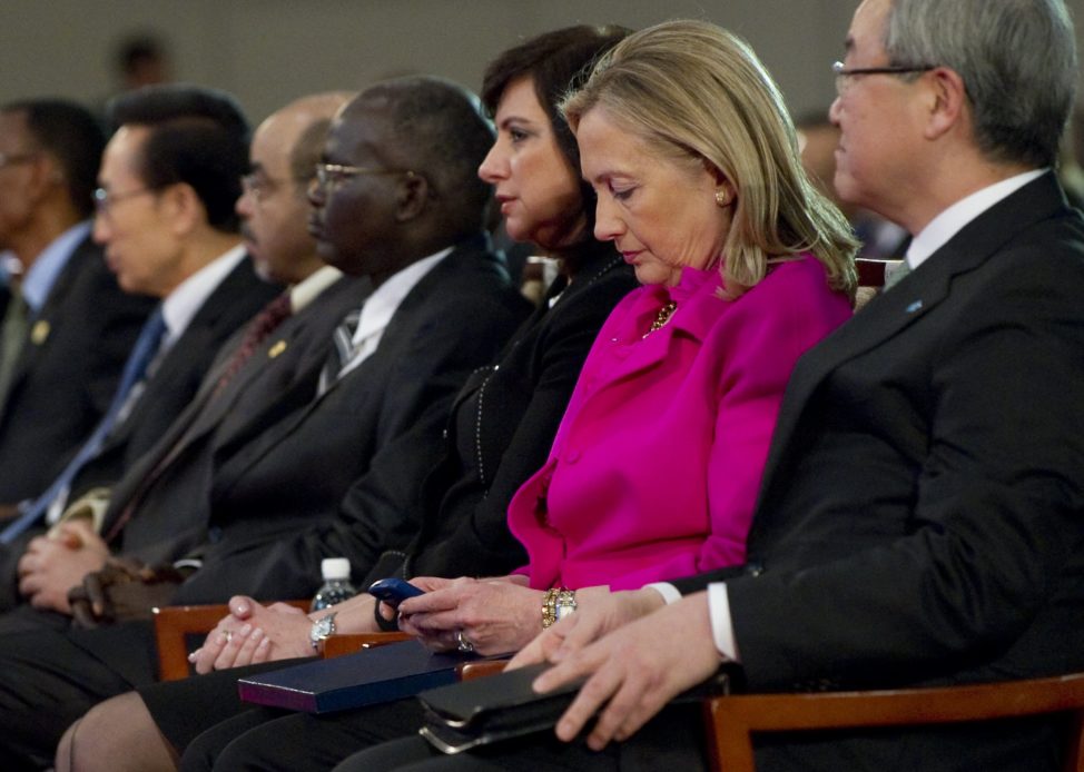 U.S. Secretary of State Hillary Clinton, 2nd right, checks her Blackberry phone alongside South Korean Foreign Minister Kim Sung-hwan, right, as she attends the Fourth High Level Forum on Aid Effectiveness in Busan, South Korea Wednesday, Nov. 30, 2011. (AP)